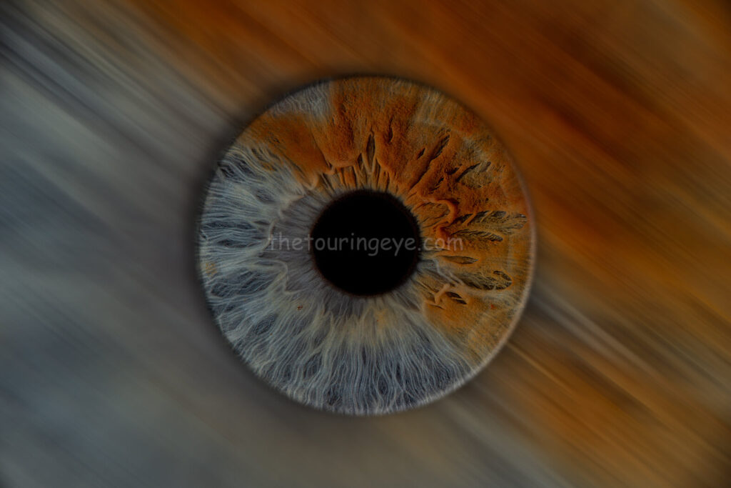A half blue, half brown eye iris hand edited to portray a blurred background effect. Eye art. Iris art. Hand edited artwork. Eye photography. Iris photography. The Touring Eye.