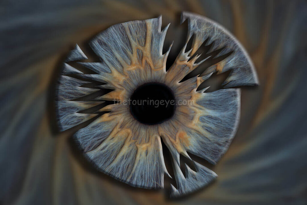A blue eye iris with a Central heterochromia hand edited to portray a shatter or splatter effect. Eye art. Iris art. Hand edited artwork. Eye photography. Iris photography. The Touring Eye.